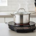 countertop induction cooktop heating a stainless steel pot evenly