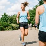 Women wearing a lightweight grey moisture-wicking workout top during an outdoor run on a sunny day