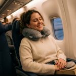 Traveler relaxing on an airplane wearing a comfortable memory foam neck pillow.